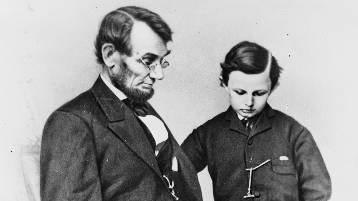 Abraham Lincoln and his son Tad looking at an album of photographs.